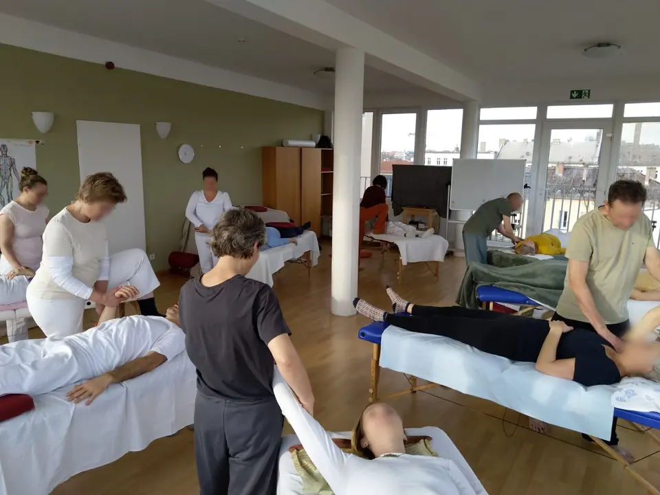 Anonymisierte Unterrichtsszene: Shiatsu-Behandlungen auf Liegen im Kursraum